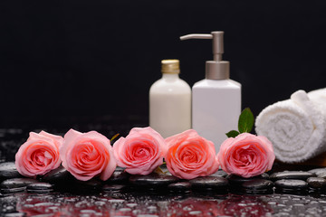 row of rose with massage oil ,towel with therapy stones