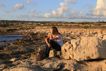 Naklejka na ściany i meble Thinking young (25-30) Sicilian girl near the beach at sunset. 