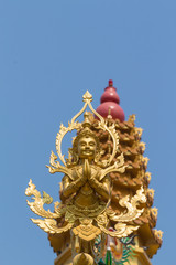 the gold deva statue with worship background