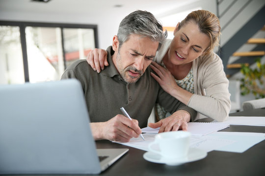 Couple calculating financial savings on internet