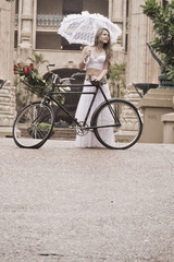 Young attractive woman walking outdoors with vintage bicycle