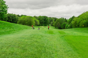 Golfplatz im Frühling mit Paar beim Abschlag