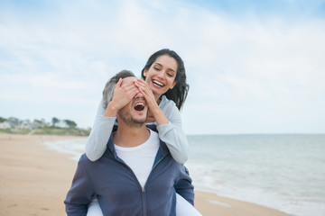 A beautiful couple is posing holding eachother at the beach