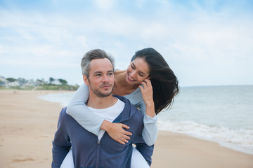 Obraz premium A beautiful couple is posing holding eachother at the beach