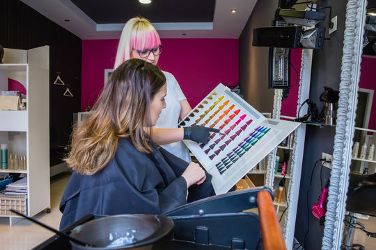Woman looking with hairdresser a hair dye palette