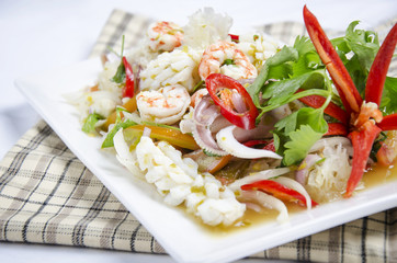 A plate of seafood dressing with red chili
