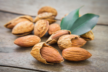 Almond with leaves on wooden table