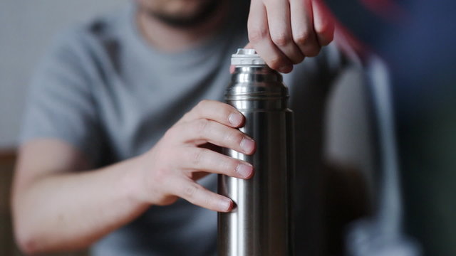 the guy at the table spins cover thermos