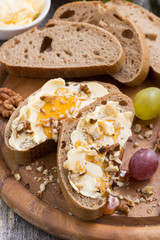bread with butter, honey and nuts, vertical, close-up
