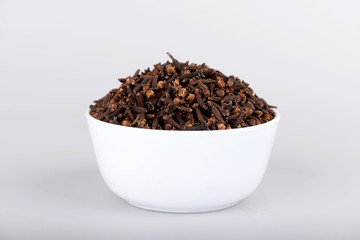 Cloves in white bowl with white background