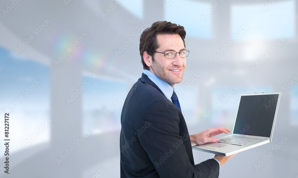 Poster Composite image of smiling businessman using a laptop
