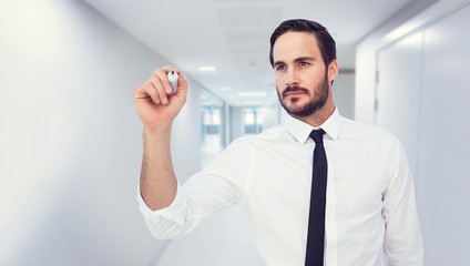 Composite image of focused businessman writing with marker