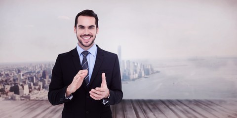 Composite image of happy businessman standing and applauding