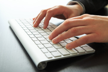Female hands working at a keyboard/computer.