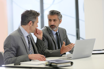 Businessmen working on laptop computer