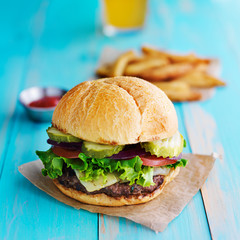 cheeseburger with fries and ketchup on rustic table top