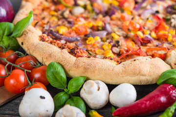 Fototapeta na wymiar Fresh homemade vegeterian pizza with ingredients, overhead