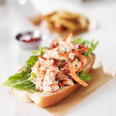 lobster roll on wax paper with fries