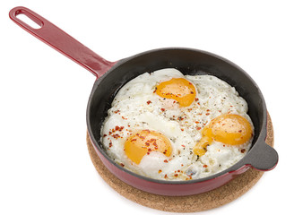 Fried egg in iron pan isolated on white background.