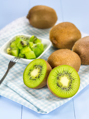 Group of kiwi fruit (cut up and whole) on the wooden table