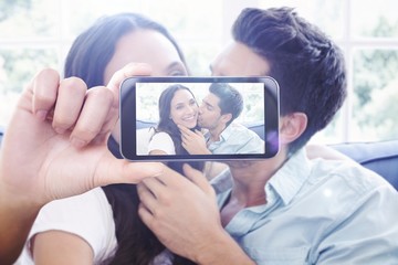 Composite image of hand holding smartphone showing