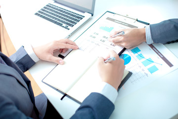 Two businessmen looking at report and having a discussion in off