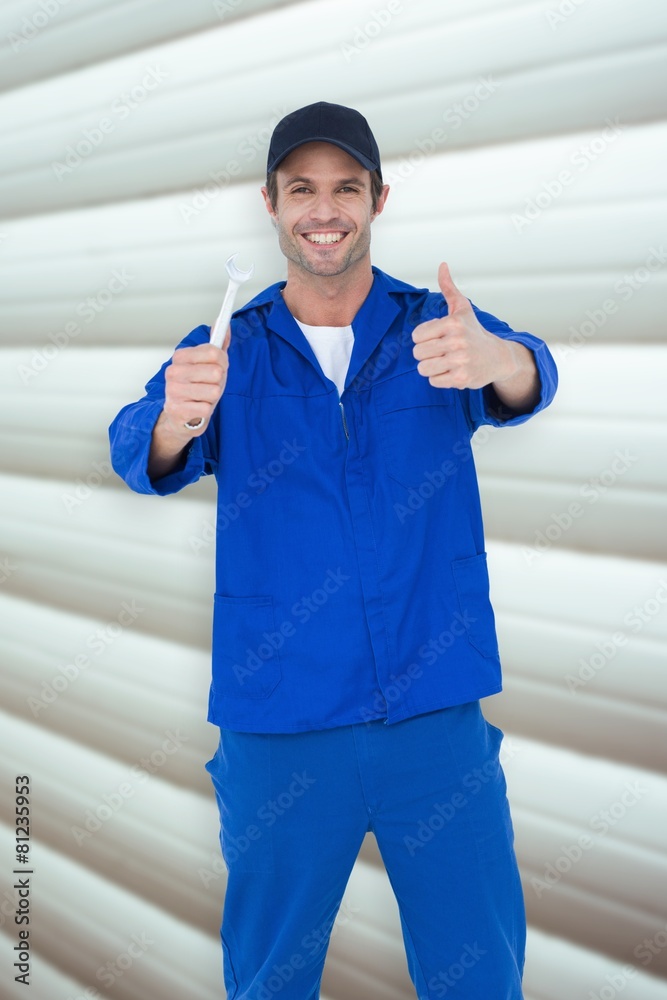 Poster composite image of happy mechanic holding spanner