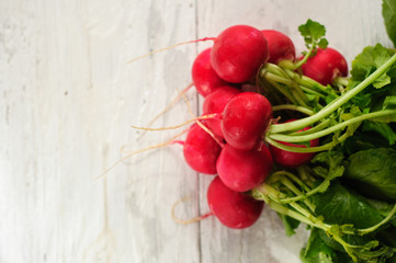 Bunch of fresh radishes on white board
