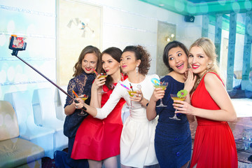girls clinking glasses of cocktails at the party