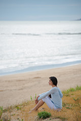 Naklejka na ściany i meble Woman meditating face to the ocean