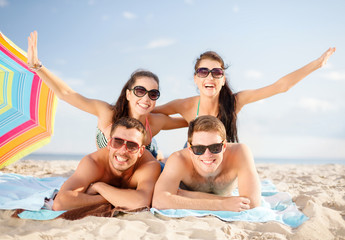 group of happy friends having fun on beach