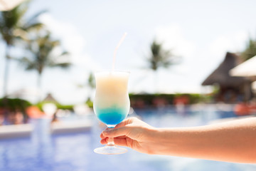 close-up of hand holding glass with cocktail