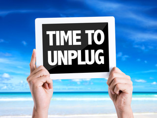 Tablet pc with text Time To Unplug with beach background