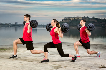 young group picking up barbell weight