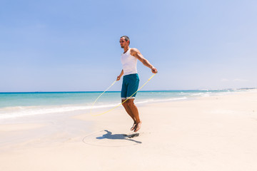 handsome man skipping on the beach