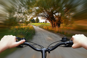 Fototapeta na wymiar Bike riding on a dirt road. First person view.