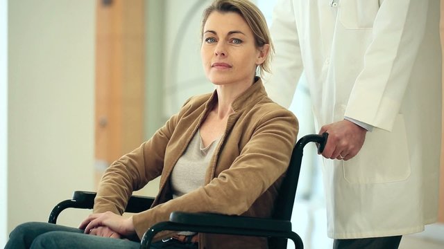 Sad mature woman sitting in wheelchair
