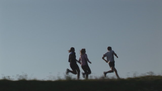 three runners on hill