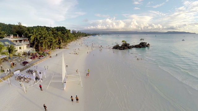 Aerial flight above white beach and Willy's Rock at Boracay Beac