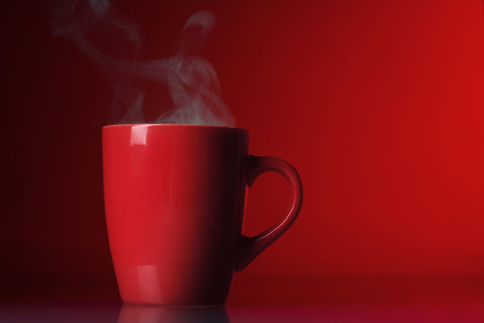 Red cup with steam over red background