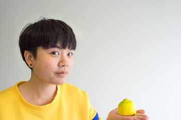 Portrait of young happy woman with lemon, indoors