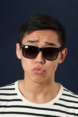 Disappointed young Asian man in sunglasses