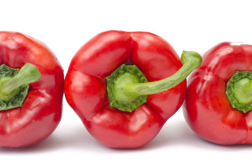 detail of three red pepper on a white background