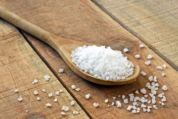 Salt in spoon on a wooden table
