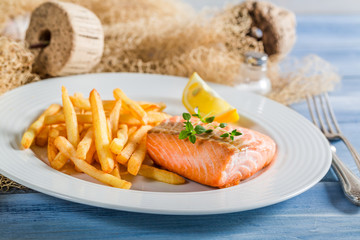 Homemade salmon with chips served on plate