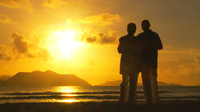 elderly couple drinking wine in sunset