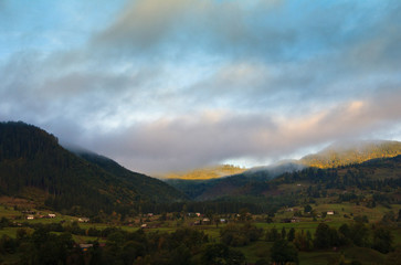 Fototapeta na wymiar Summer landscape with a mountain village in the mist.