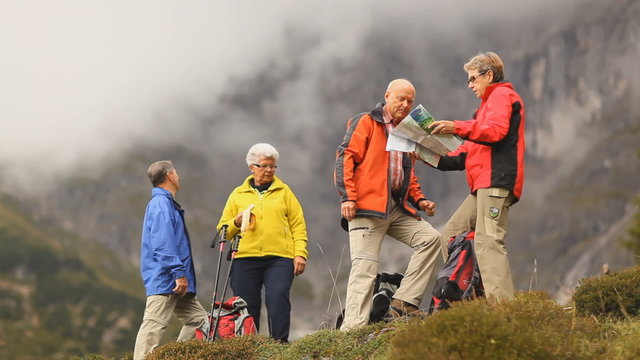 four senior hikers looking at map wide