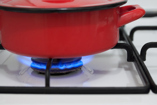 Red pan on the gas stove burning flame