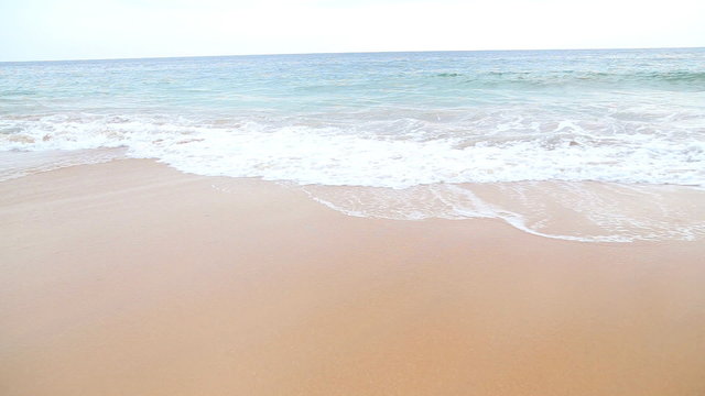 Waves washing over white sand in the tropics